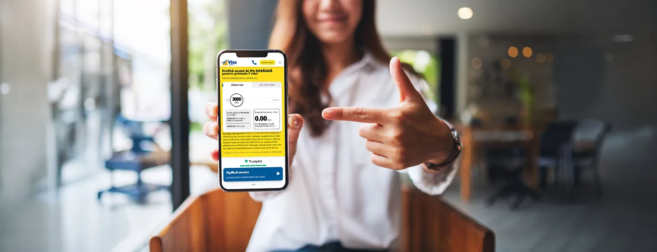 Ce e nou la Creditul Viva? 1 Femeie care arata ecranul telefonului, unde este deschis site-ul Viva Credit si se poate aplica pentru Creditul Viva.
