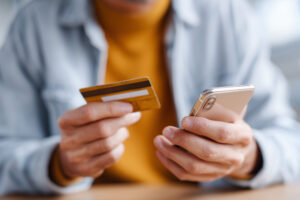 Când este util să ai o linie de credit de la Viva Credit ca rezervă financiară? 2 barbat utilizand telefon si card